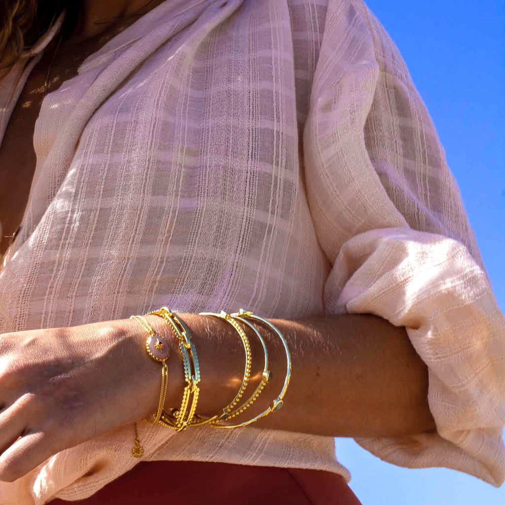 Model wears Oval Peach moonstone bracelet with double chain and slider toggle in gold vermeil  