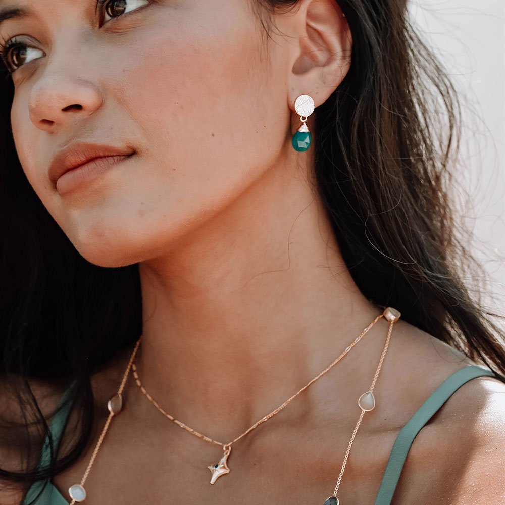 Model wears princess of wales  green onyx drop stone earrings by Azuni
