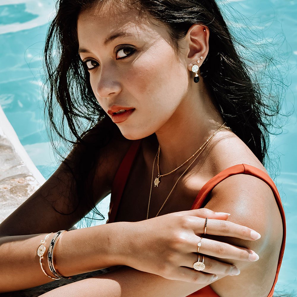 Model in swimming pool wearing Azunis´ Black onyx drop stone earring style worn by The Princess of Wales 