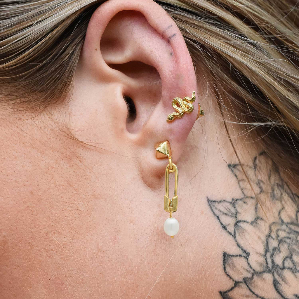 model wearing gold drop pearl and safety pin earrings. Stud and safety pin earrings with freshwater pear drops. by Azuni London 